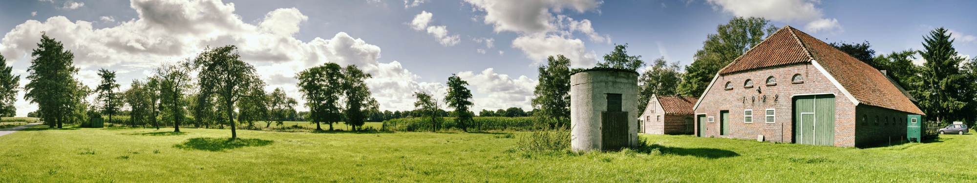 Das Haupthaus bei Sonnenschein einschließlich der Schmiede, des Schweinestalls und des Siloturms